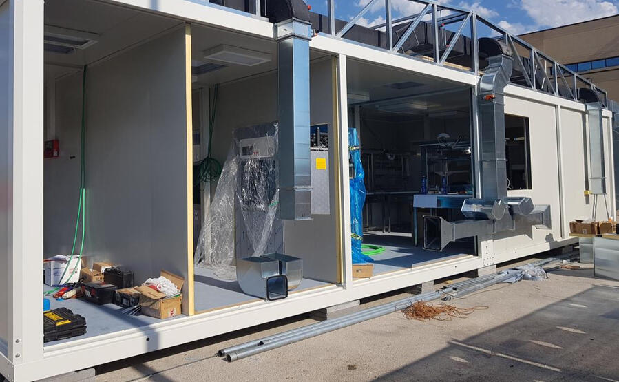 Unidad sanitaria modular prefabricada en fase de acondicionamiento, con instalaciones de ventilación y equipos internos